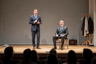 Deux acteurs en costume sur scène dans une pièce de théâtre comique, expression de surprise, décor minimaliste